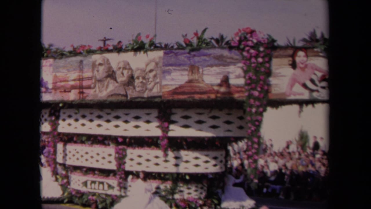 Decorated parade float with floral trim and painted scenic panels.