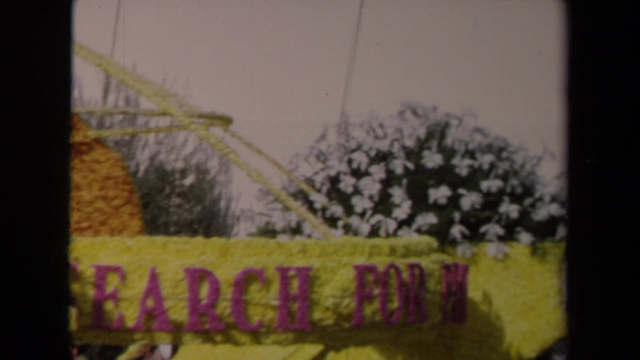 Yellow parade float section with purple lettering reading part of Search For.