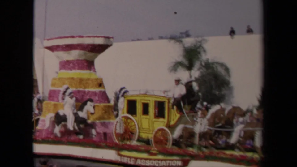 A 1967 Los Angeles parade view shows the floral float from the side, with the yellow stagecoach, horses, palm tree, and crowd visible.