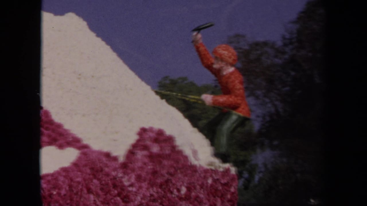 Orange-clad climber figure on a white and pink float slope beside dark trees.