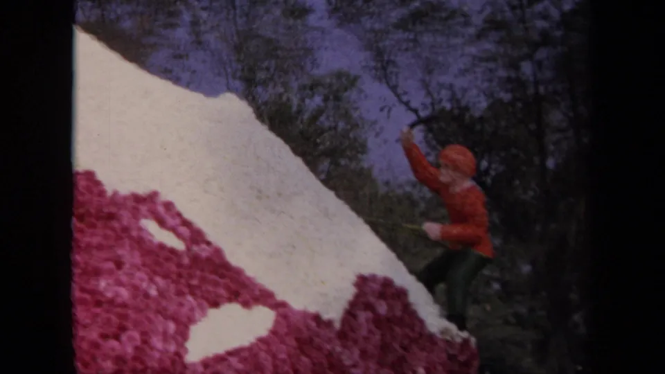 Final frame detail of the 1967 Los Angeles floral mountain float, showing an orange climber figure against trees and sky.