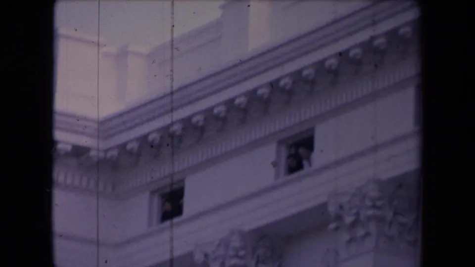 A closer upward view shows the building’s cornice, window openings, and classical trim in soft 8mm focus.