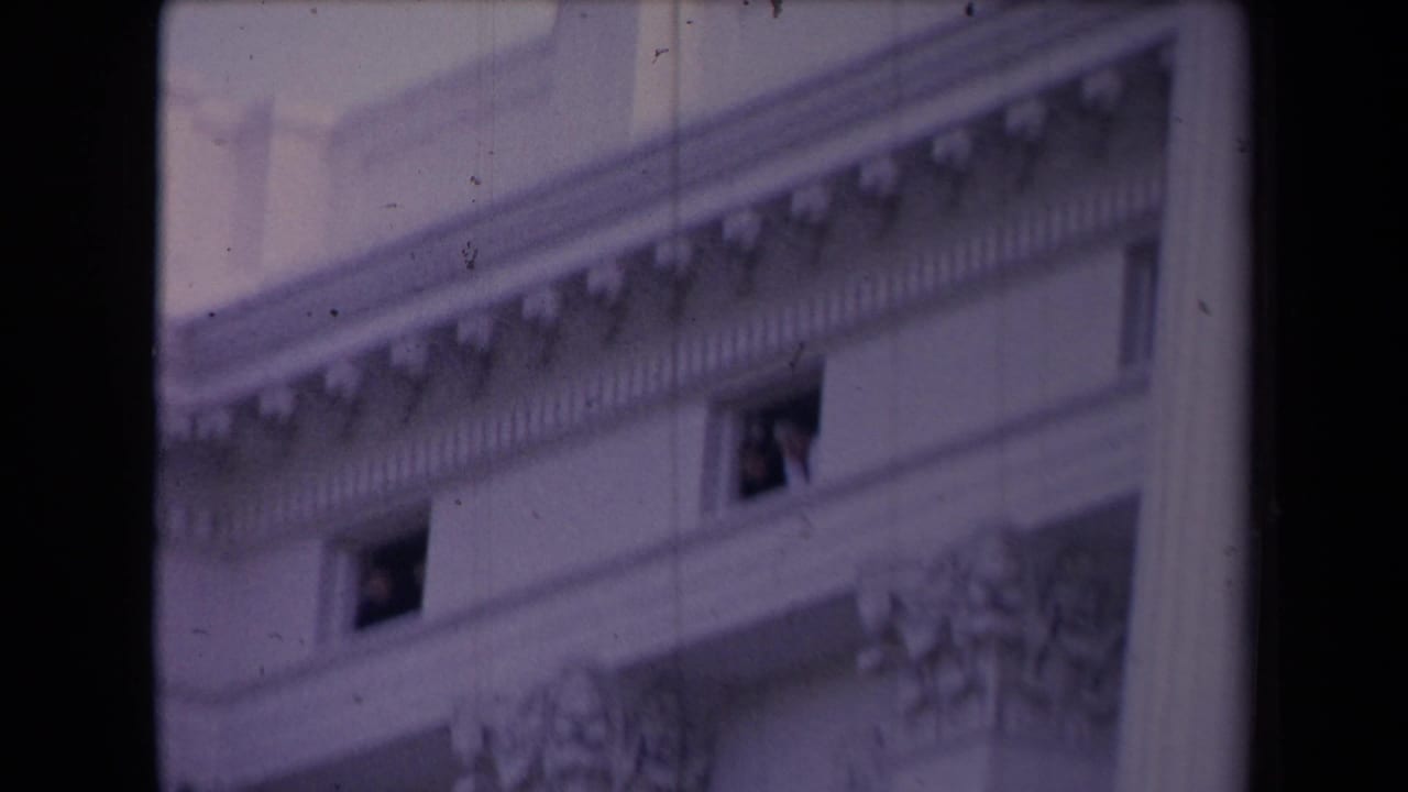 Ornate facade with two small windows, one showing a person near the opening.