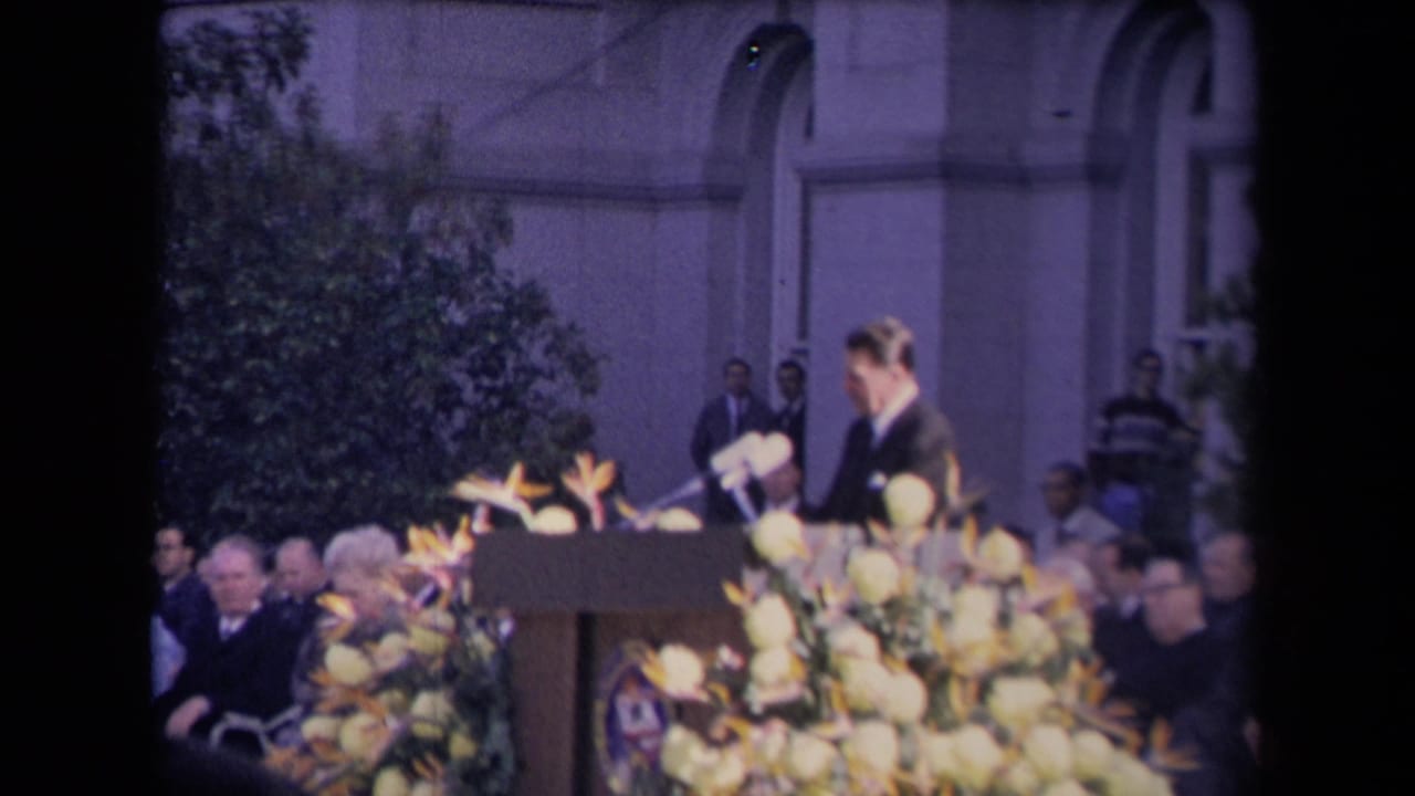 Ronald Reagan appears at a podium with microphones, flowers and seated attendees during a reported 1967 inauguration event.