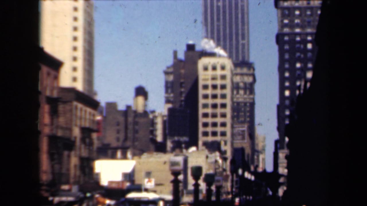 1941 New York 8mm view of high-rise buildings, rooftop water tanks, traffic signals, and a bright blue sky.