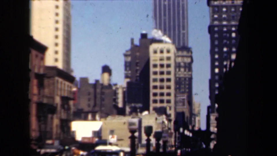 1941 New York 8mm view of high-rise buildings, rooftop water tanks, traffic signals, and a bright blue sky.