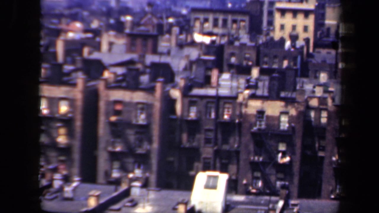 High-angle 1941 New York city view showing closely spaced apartment facades, fire escapes, and rooftop equipment.