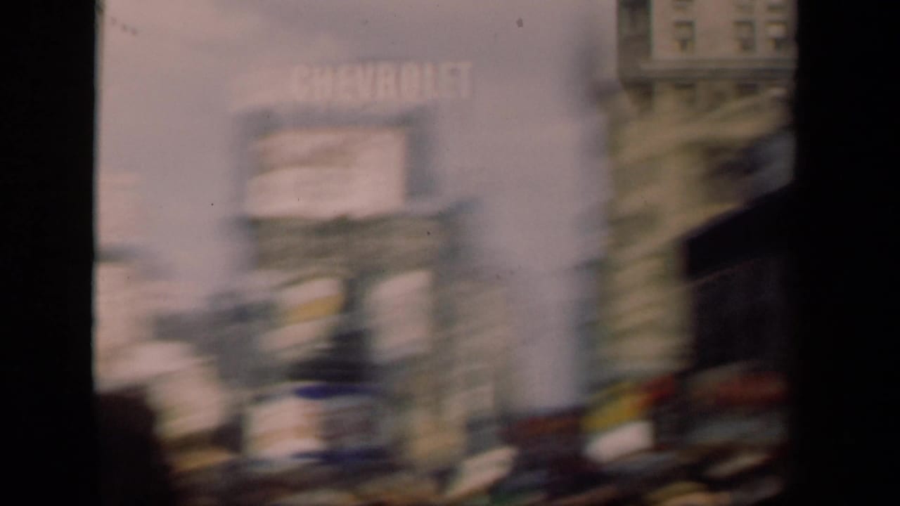 Motion-blurred 1941 New York street view with pedestrians and large commercial signs along tall building facades.