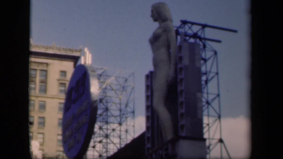 1941 New York view looking up at a tall sculptural figure beside a Pepsi-Cola sign, building facade, and metal sign framework.