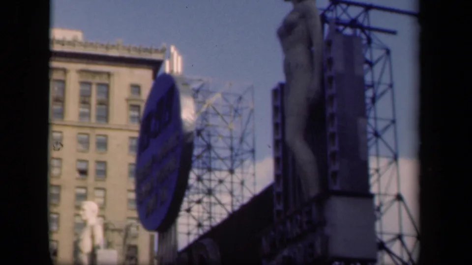 1941 New York frame showing a statue, large Pepsi-Cola sign, adjacent building windows, and exposed billboard framework.