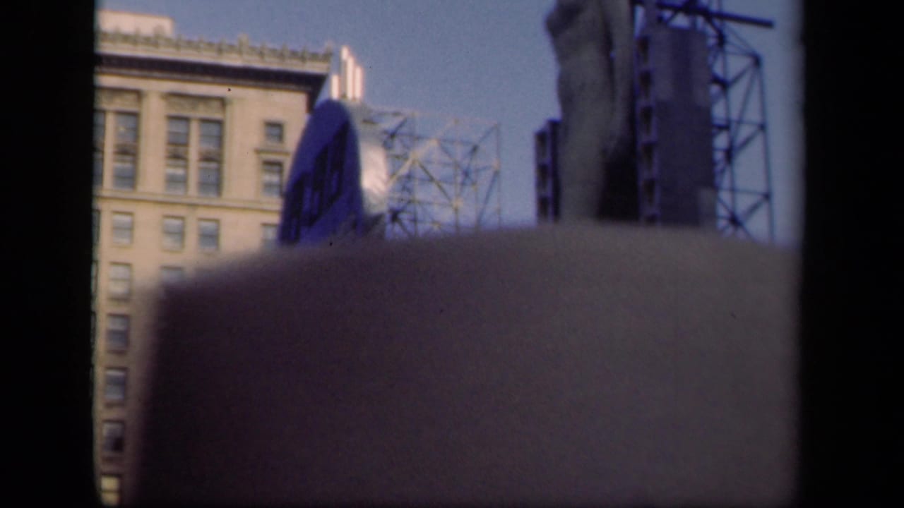 Blurred city building and circular blue sign partly obscured by a dark foreground band.