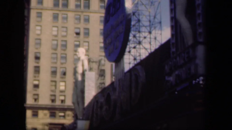 1941 New York street frame with a circular blue billboard, mannequin-like display figure, dark storefront signage, and a tall windowed facade.