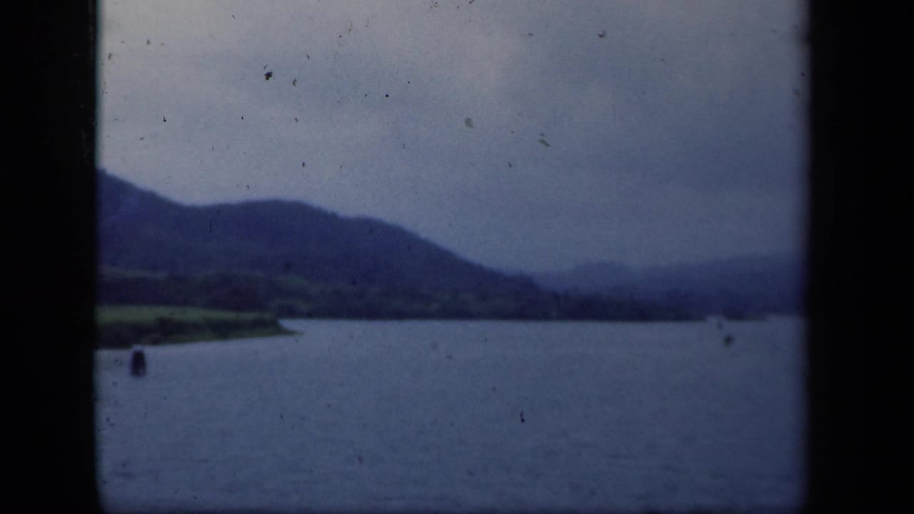 Water and distant mountain ridge with a small dark buoy near the center-left.
