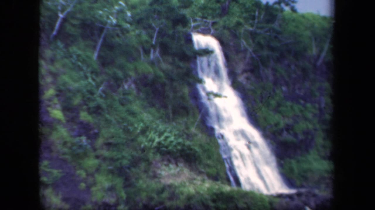 1941 New York 8mm frame showing a white waterfall dropping down a forested rocky slope.