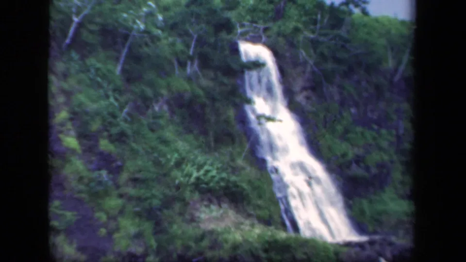 1941 New York 8mm frame showing a white waterfall dropping down a forested rocky slope.