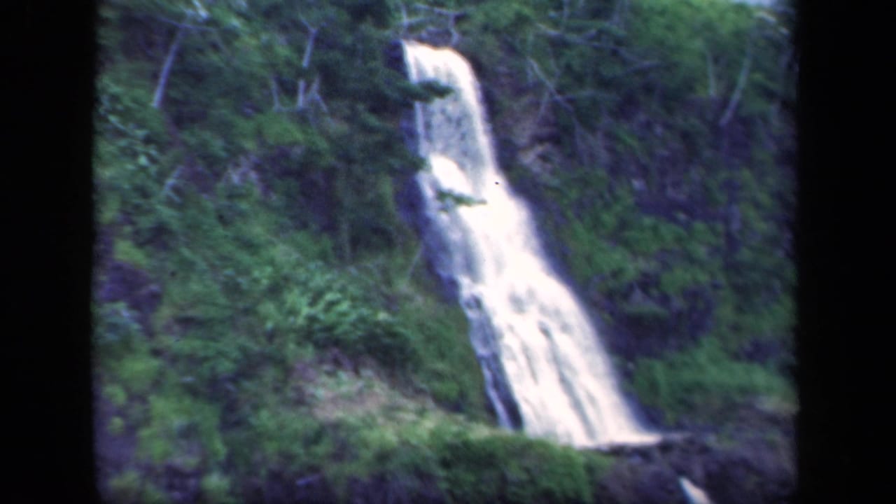 1941 New York 8mm view of a bright waterfall framed by trees and thick green vegetation.