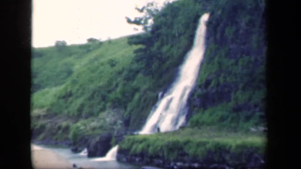 1941 New York 8mm frame with a tall waterfall descending to a small river or pool below.