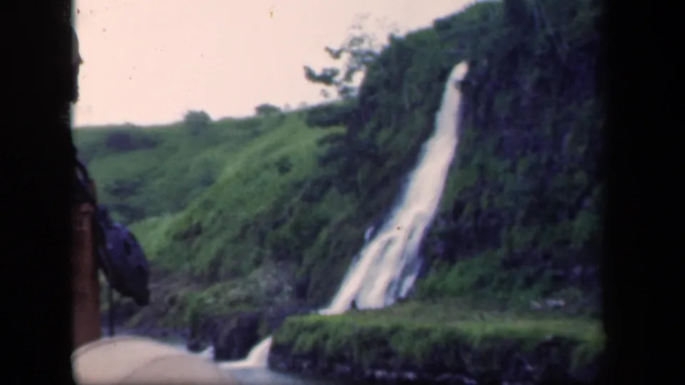 1941 home-movie view of the waterfall and surrounding green hillside, with the 8mm frame edge visible.