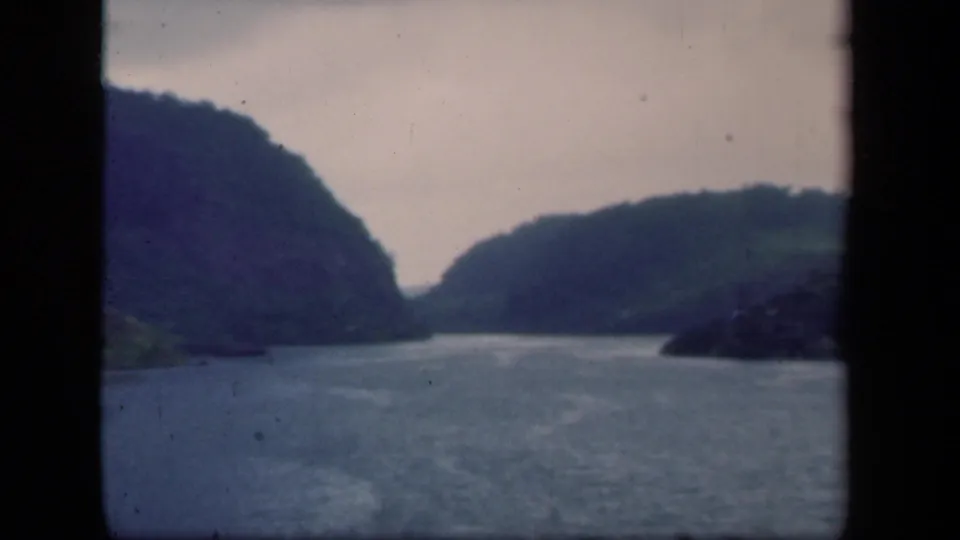 1941 New York 8mm lake scene with rippled water, dark green hills, soft horizon, and visible gate edges.