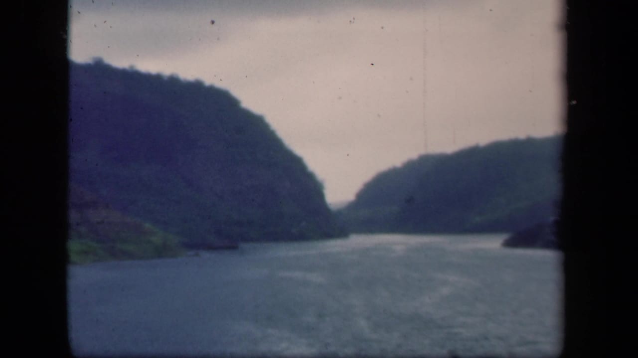 1941 New York 8mm frame of a calm waterway and layered hills, with the scene divided by a dark central edge.