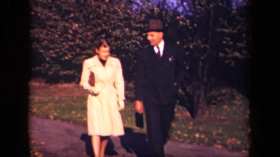 A 1941 New York park shot shows the woman glancing toward the man as they walk in mid-century clothing.