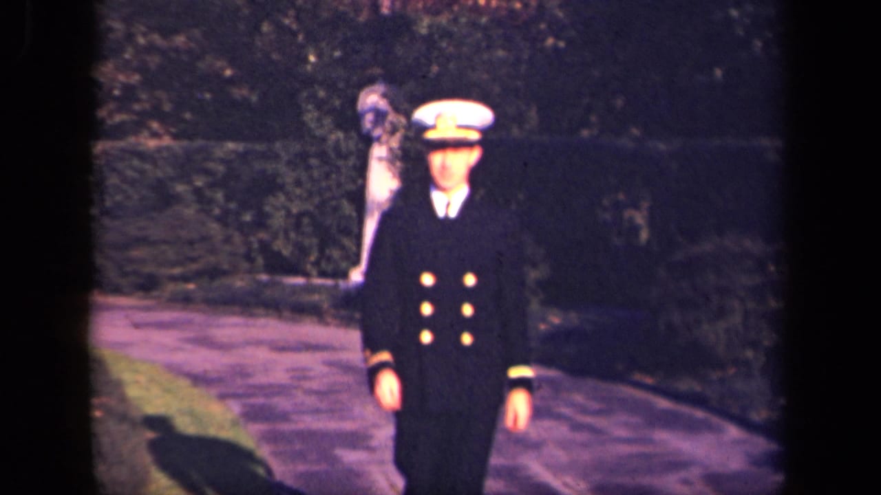 In a 1941 New York 8mm home movie, a young Navy officer walks down a garden path toward the camera.