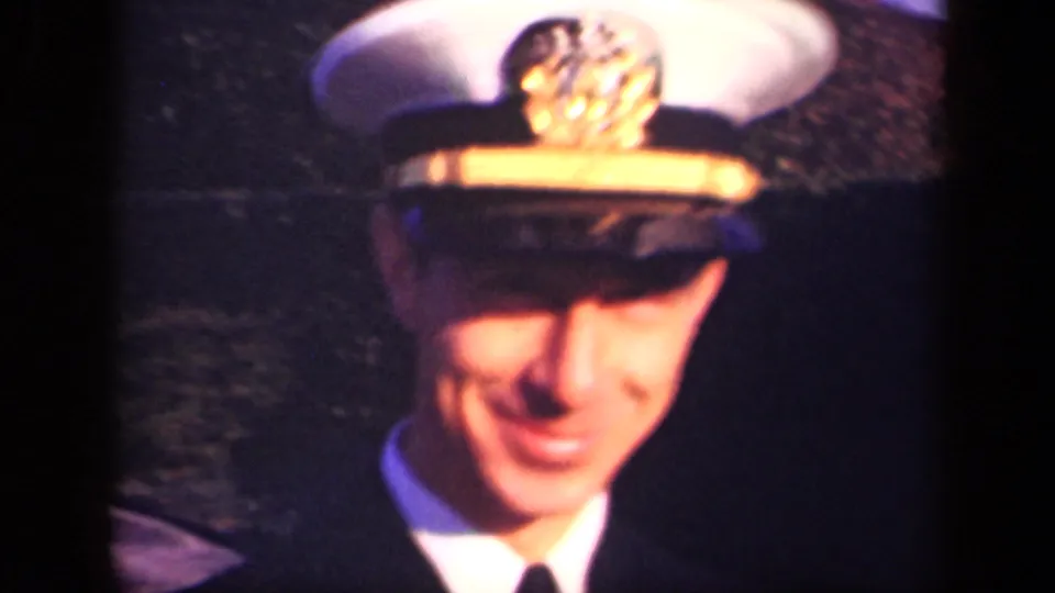 The clip ends on a soft close-up of the smiling Navy officer in cap and uniform, outdoors in New York.