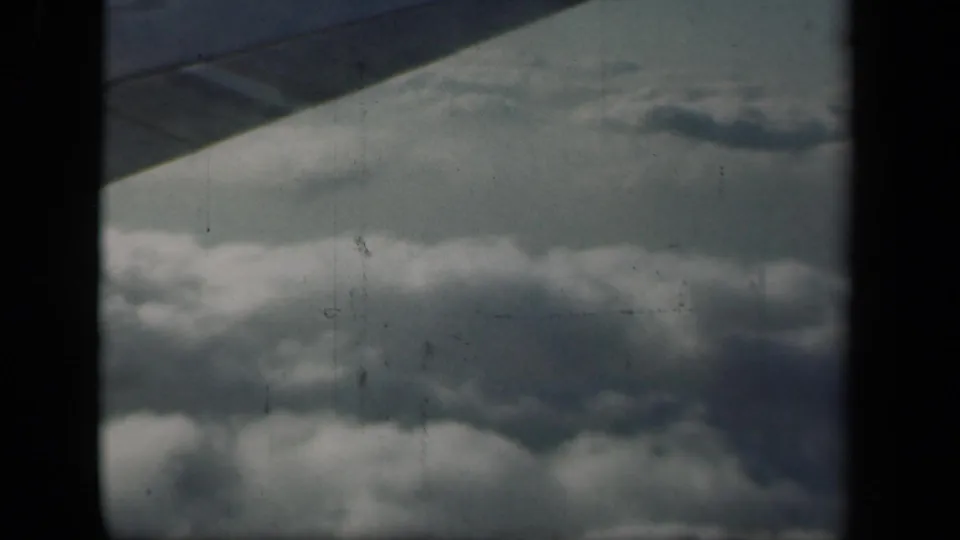 In this 1941 New York flight view, cloud formations fill the lower frame while the window edge and film divider darken the sides.