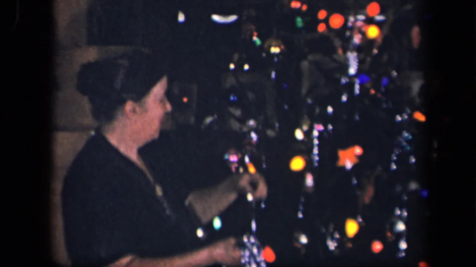 The woman turns toward the decorated Christmas tree in the supported 1942 Sebring, Ohio interior scene.
