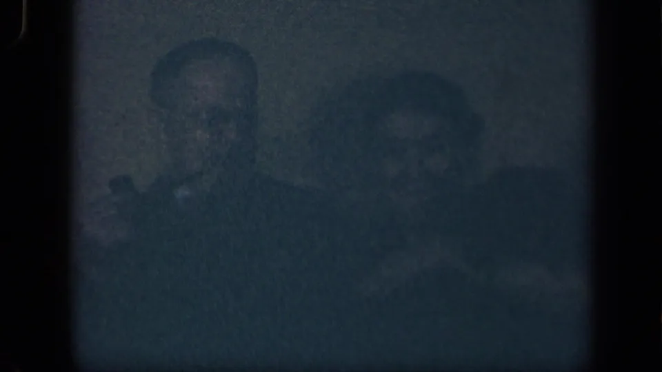 Final 1942 Sebring, Ohio 8mm frame with two adults seated close together, the man more visible and the woman softly smiling beside him.
