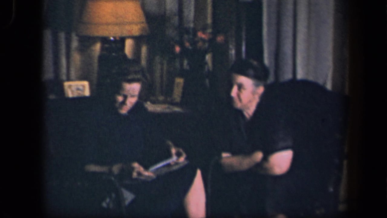The woman appears to read from a card or booklet while the seated man looks toward her in a 1942 Sebring, Ohio living room.