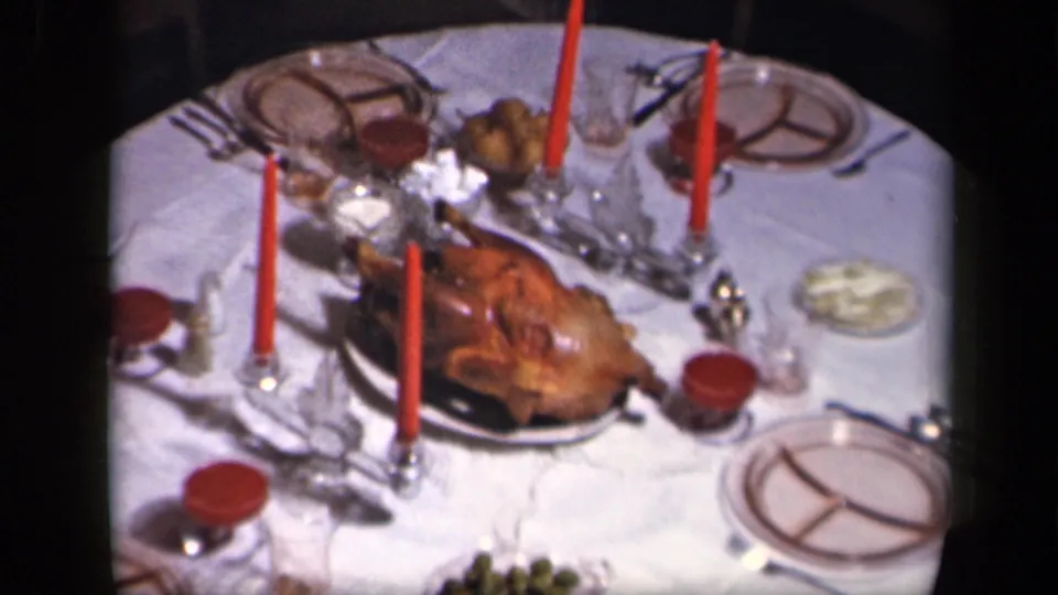 1942 home-movie frame from Sebring, Ohio showing a close view of the Thanksgiving turkey, candles, plates and serving dishes.