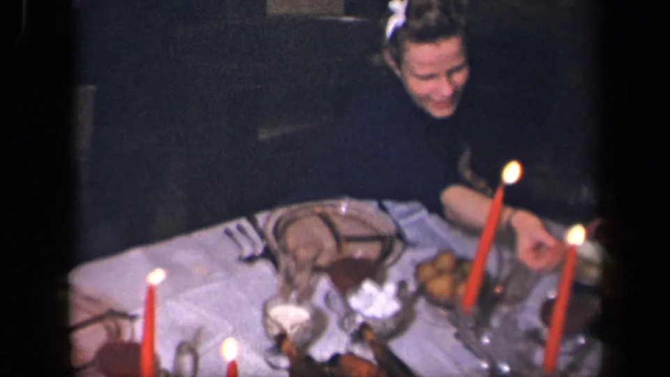 The closing frame shows two adults at the 1942 Sebring dinner table with red candles, glassware, plates, and food.