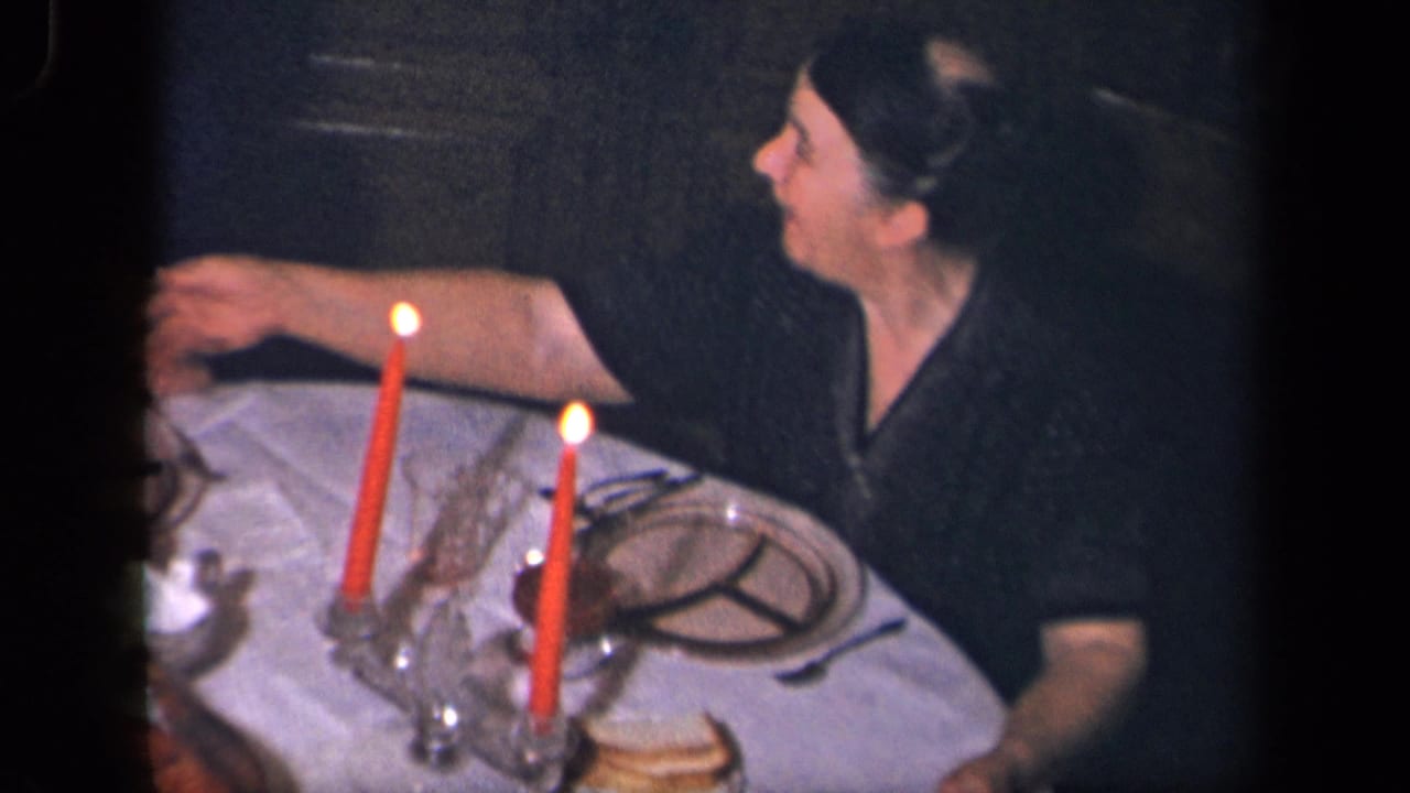 A woman in a dark dress sits at a candlelit dinner table in the Sebring, Ohio home interior, with plates and glassware nearby.