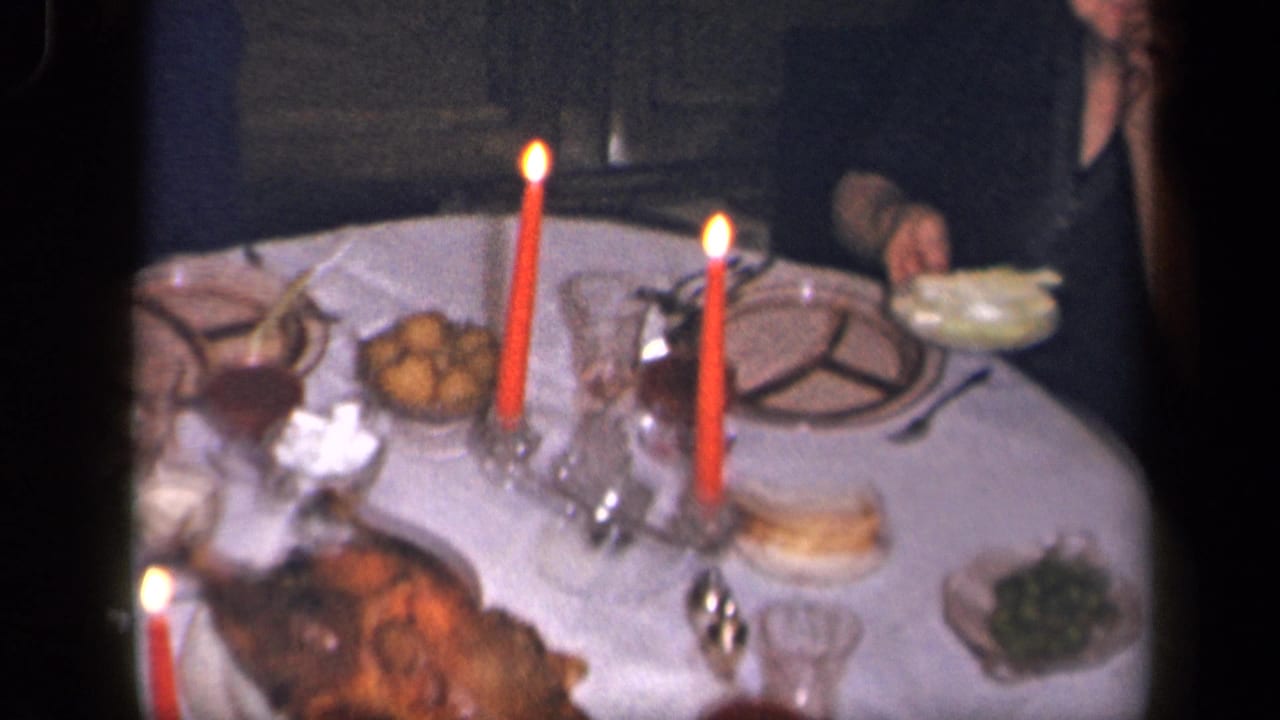 The 1942 Sebring, Ohio home-movie frame shows an overhead view of a candlelit table with serving dishes, plates, and glasses.