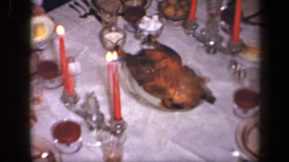 A roasted turkey sits on the candlelit dinner table in this 1942 Sebring, Ohio 8mm home-movie frame.