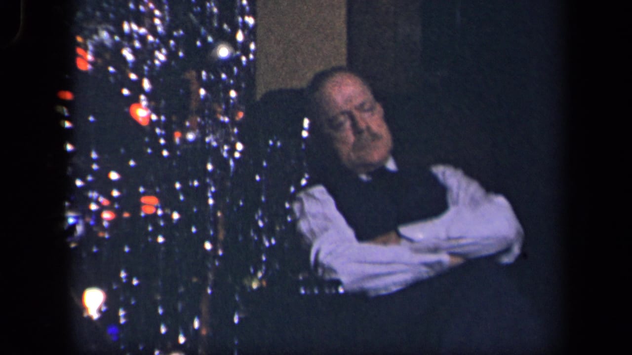 In the stated 1942 Sebring, Ohio setting, a man in a white shirt and dark vest sleeps beside a lit Christmas tree.
