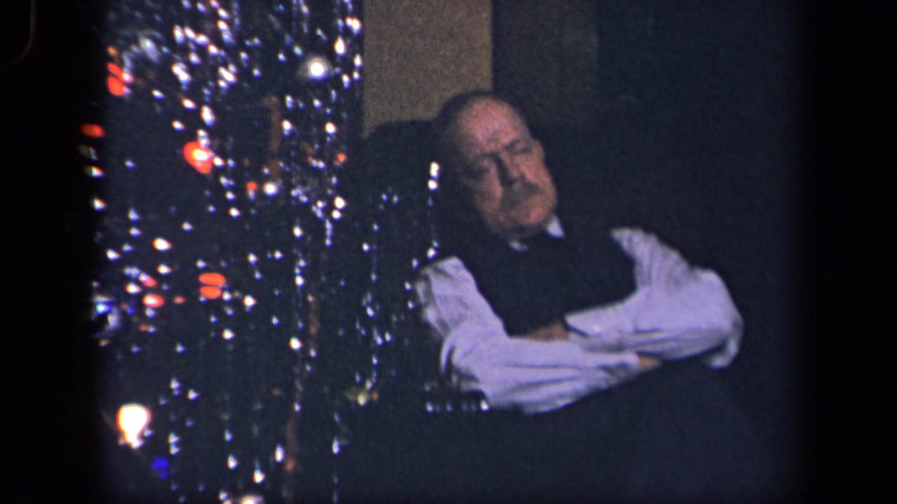 In the supplied 1942 Sebring, Ohio home-movie context, an older man rests in an armchair next to a decorated Christmas tree with tinsel and colored lights.
