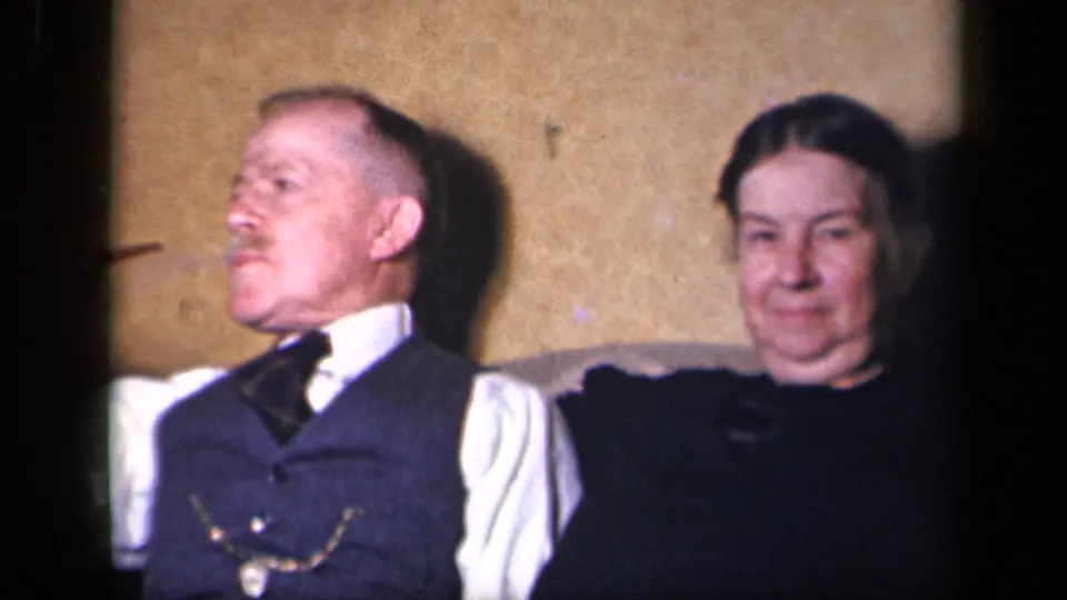 The older woman faces the camera while the man beside her looks left in this 1942 8mm domestic scene.