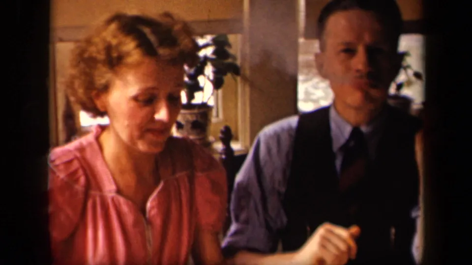The woman in pink looks down as the seated man remains beside her in the Sebring, Ohio interior identified by metadata.