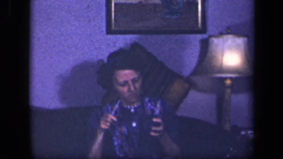 In the final frame, the woman continues handling knitting materials on a couch in the Sebring, Ohio interior, lit by a nearby table lamp.