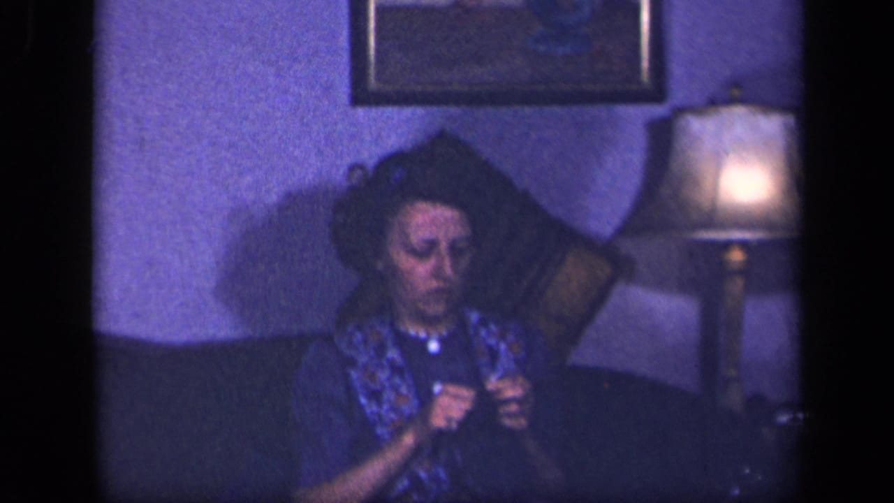 The woman remains seated on the couch in the 1942 Sebring interior, focused on crochet work with a lamp glowing at her side.