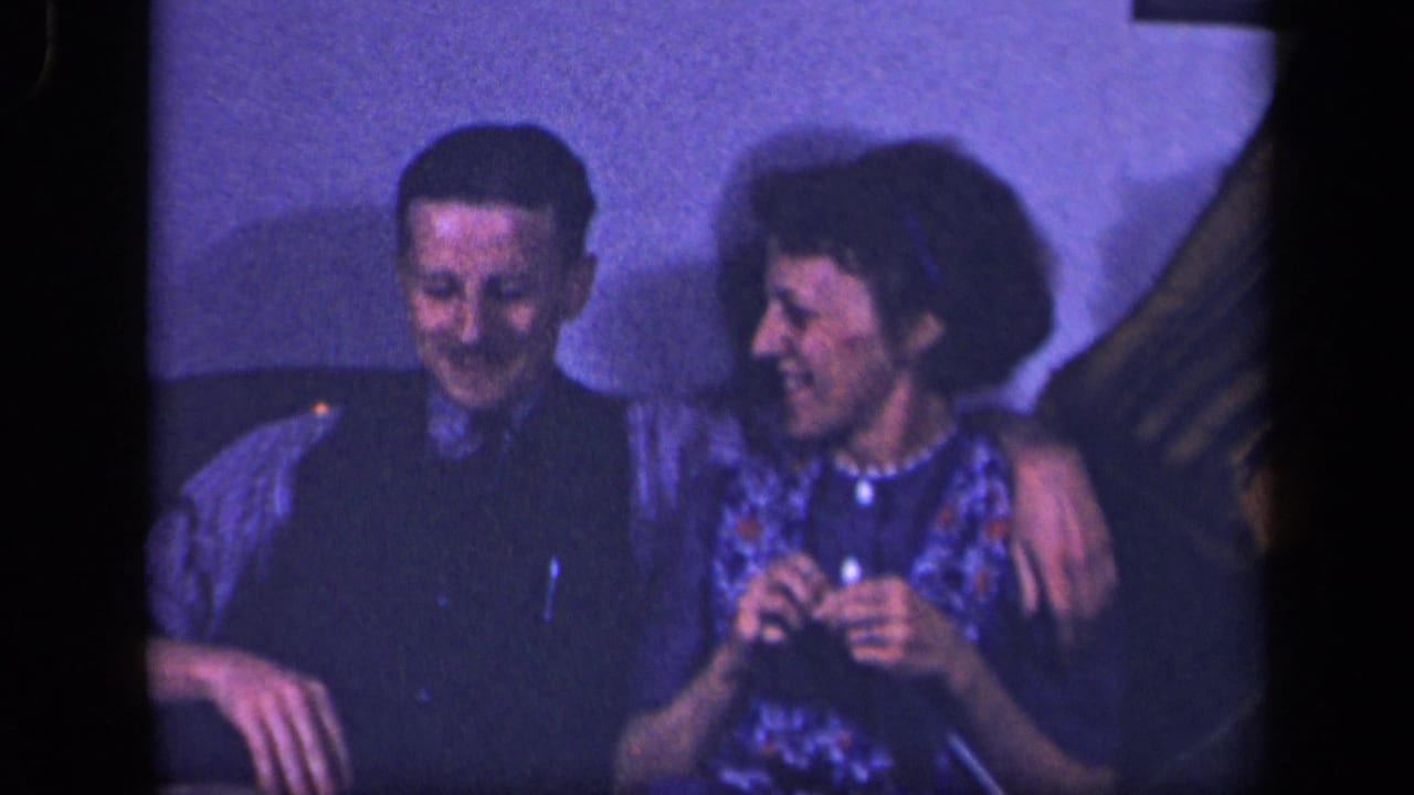 In 1942 Sebring, Ohio home-movie footage, an adult man sits with his arm around a woman on a couch as both smile.