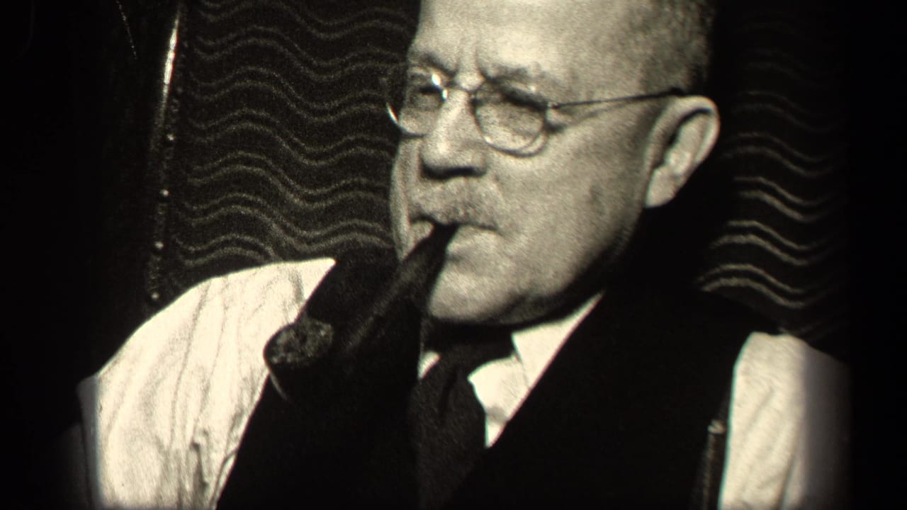 Older man in Sebring, Ohio 1942 home-movie footage wears glasses, vest, and tie while smoking a pipe indoors.