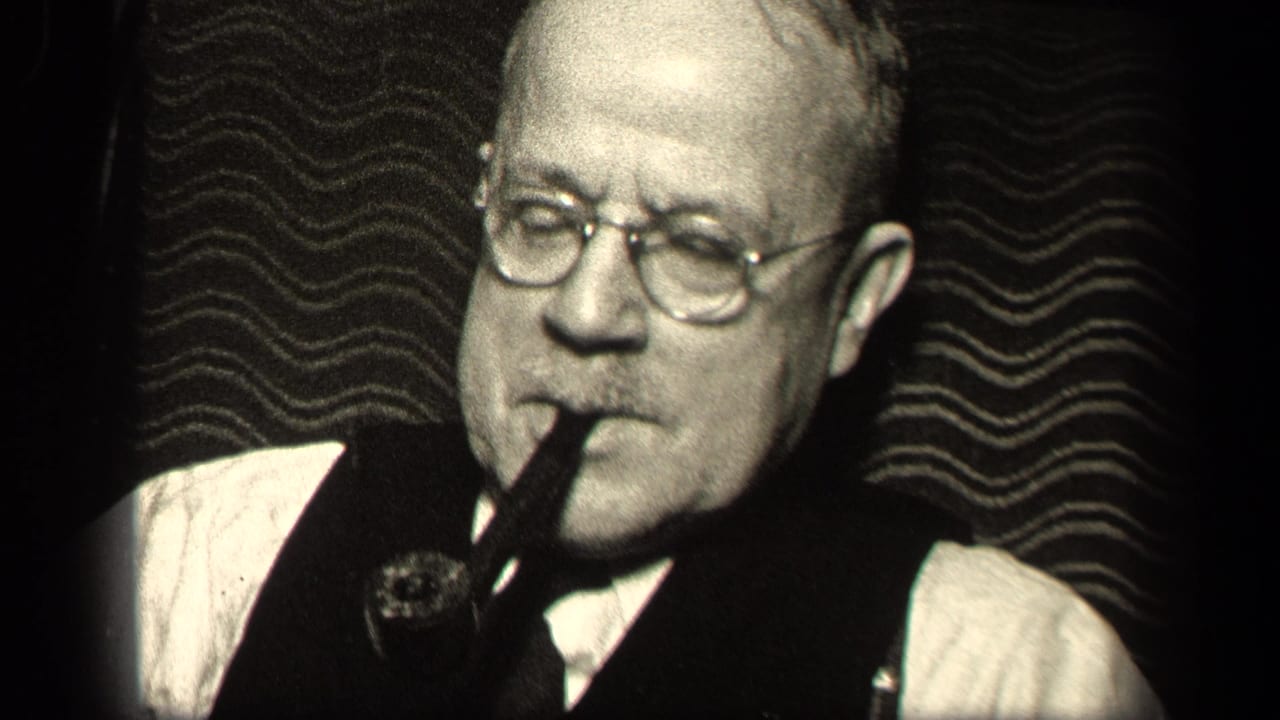 1942 Sebring, Ohio frame of an older man wearing glasses and a vest, pipe held at his mouth in close-up.