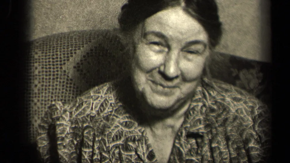 A close 8mm frame shows the seated woman smiling warmly in a domestic interior in Sebring, Ohio, 1942.