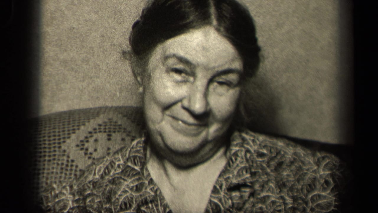 Older woman in Sebring, Ohio 1942 home-movie footage smiles toward the camera while seated against textured upholstery.