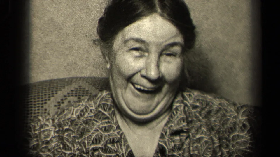 In the Sebring, Ohio 1942 home movie, the seated woman laughs broadly with her eyes narrowed and shoulders relaxed.