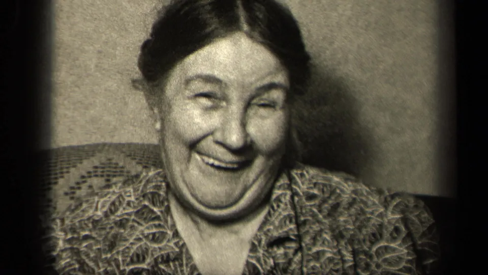 The 1942 Sebring, Ohio home-movie frame shows the older woman laughing in close-up beside dark film-frame edges.