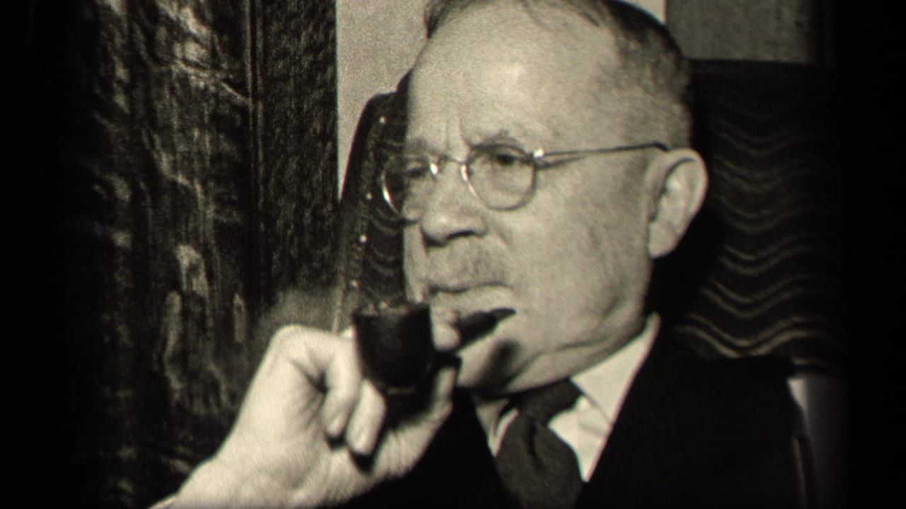 In the 1942 Sebring, Ohio home-movie frame, the seated man turns in profile with a pipe, suit, tie, and round eyeglasses visible.